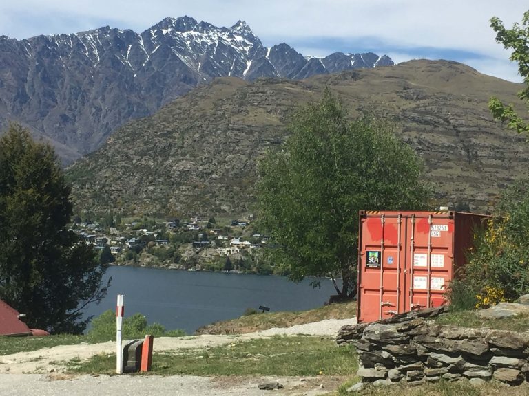 Red shipping container in remote New Zealand location.