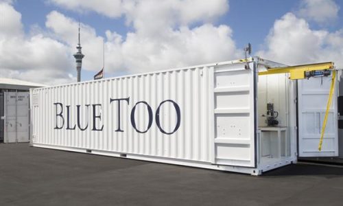 This image shows the inside of a fitted-out container with shelving, storage drawers, benches and lighting.