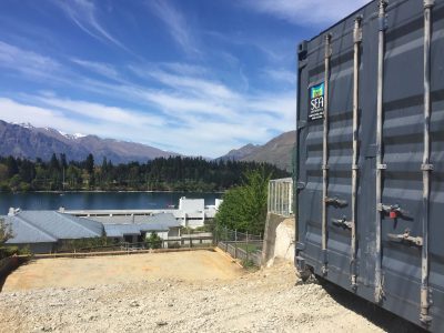 Black shipping container placed on a construction site