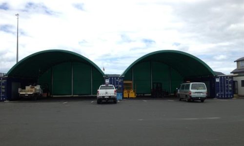 Two large shipping container shelters at industrial site