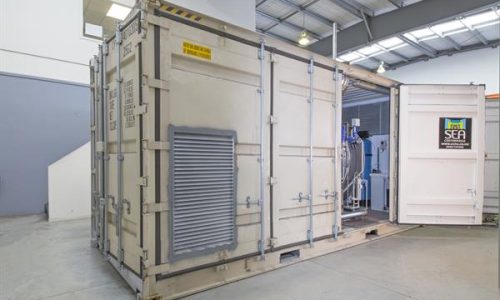 Modified shipping container with ventilation louvre and open doors for plant room fit out