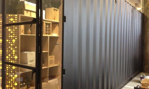 Wooden interior shelving inside a modified shipping container.