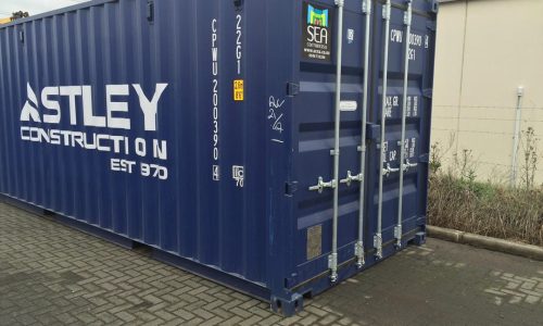 Blue shipping container branded with Astley Construction