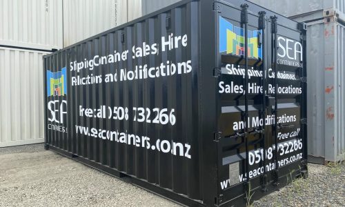 Black shipping container branded with SEA Containers sales and hire information